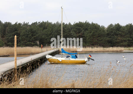 24 April 2018, Deutschland, Prerow: ein Segelboot vor Anker in der Darßer Ort not Port im Kernbereich der Nationalpark Vorpommersche Boddenlandschaft liegen ("Nationalpark Vorpommersche Boddenlandschaft"). Der Zugang zum Hafen Schlick regelmäßig und so muss häufig ausgebaggert, um für die Rettung Cruiser der DGzRS "Theo Fischer" in Betrieb bleibt. Foto: Bernd Wüstneck/dpa Stockfoto