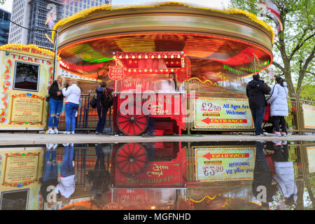 South Bank, London, 28. April 2018. Nach einer eher kalten und nassen Tag über London, Pfützen auf der South Bank, Erstellen bunte Reflexionen eines nahe gelegenen Merry-go-round. Touristen und Einheimische, die das Londoner sind jedoch unbeirrt durch das Wetter, ein Spaziergang entlang des Flusses und das Drängen in die Bars und Cafes in der Nähe der Southbank Centre. Credit: Imageplotter Nachrichten und Sport/Alamy leben Nachrichten Stockfoto