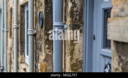 Gusseisen wasser Fallrohre Line up gegen Herunterfallen sichern dem Kalkstein von terrassierten Cottages in der Stadt der Cotswold von Chipping Campden Stockfoto