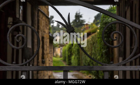 Aufwändig verzierten Kunstschmiedearbeiten kunstschmiedearbeiten Tore eine Gasse zwischen den alten historischen Häusern, die vorderen Moreton in Marsh street Stockfoto