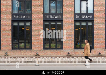 Man Walking pass ein Cafe an 798 Art Zone in Peking Stockfoto