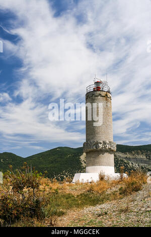 Leuchtturm auf der Halbinsel Bolshoy Krasnodarskiy Utrish, Region, Russland gegen den Kaukasus und Sommer Himmel. Stockfoto