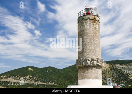 Close-up Leuchtturm an der Küste des Schwarzen Meeres auf der Halbinsel Bolschoj Utrish, Rußland gegen Kaukasus Berge und Himmel. Stockfoto