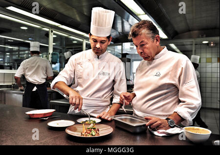 3-Sternekoch Régis Marcon (rechts) bei der Arbeit mit seinem Sohn Jacques (links) in der Küche seines Restaurants in Saint-Bonnet-le-Froid, Frankreich Stockfoto