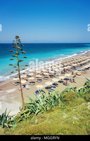 Ägäis Strand mit Sonnenschirmen in der Stadt Rhodes (Rhodos, Griechenland) Stockfoto