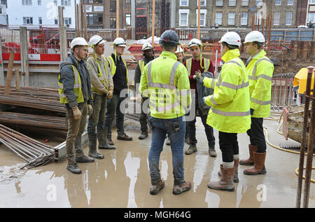 Ein "Toolbox Talk" findet auf einer Londoner Baustelle statt. Die Mitarbeiter am Standort erhalten Schulungen und Projektinformationen vom leitenden Projektmanagementteam Stockfoto