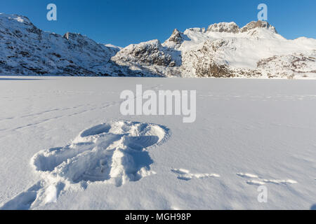 Schnee Engel im Schnee auf einem zugefrorenen Bergsee im Winter, Lofoten, Norwegen Stockfoto