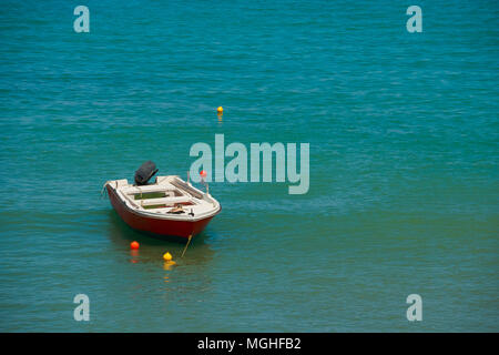 Kleines Fischerboot auf dem Meer in einem Sommertag. Europa. Unberührte Wasser Farben Schönheit. Boot steht angedockt und in Blau und Grün Meer Wasser im sonnigen Sommer dayCopy Raum widerspiegelt Stockfoto