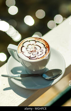 Heißer Kaffee Cappuccino in weißen Schale. Morgenkaffee. weiße Tasse Latte heißen Kaffee mit Blatt, Blumenmuster, latte Art Coffee Mug Stockfoto