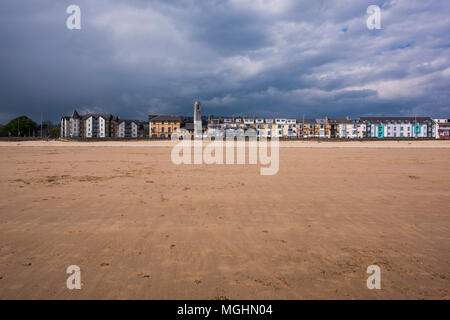 Hotels und Wohnungen entlang Oystermouth Straße mit der Brangwyn Hall Clock Tower im Hintergrund vom Strand an der Swansea Bay, South Wales, UK. Stockfoto