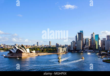 Sydneys Hafen Circular Quay mit mehreren Fähren ankommen und abfliegen und die herrliche Kulisse der Kai und das Stadtbild als Sun genommen wird Stockfoto