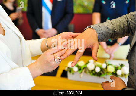 Die Braut trägt einen Ring am Finger für den Bräutigam während der Hochzeitszeremonie Stockfoto