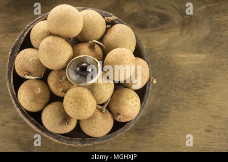 In einer Keramikschale auf einem Hintergrund aus Holz Sperrholz mit Fleck für Holz abgedeckt Longan Stockfoto