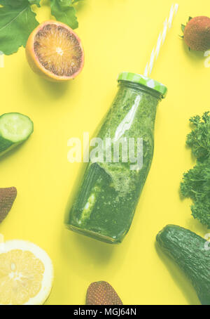 Organische und gesunden grünen Smoothie mit Banane, Spinat, Avocado, Zitrusfrüchte und Chia Samen in ein Glas Flaschen auf gelben Hintergrund withcopy Stockfoto