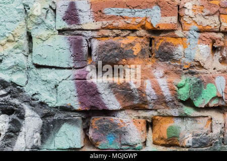 Dirty Brick City Wall, spritzt mit bunten Flecken von hellen Farben von Aerosolen. Stilvolle Muster, modischen Farben, abstrakte Hintergrund. Stockfoto