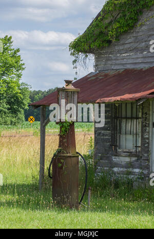 Verrostet Mailbox entlang einer Landstraße; gas Pumpe eine Erinnerung an vergangene Zeiten. Ländliche decay erzählt eine Geschichte inmitten der Rost, Vernachlässigung, und überwucherung. Stockfoto