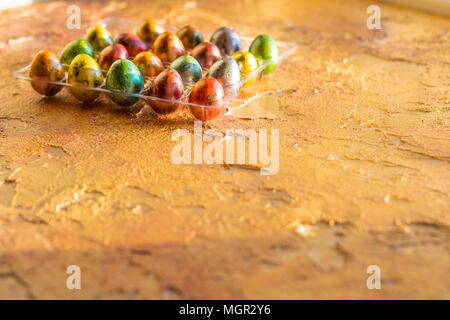 Wachtel Ei im Nest, Frühling, isoliert auf Gelb. Ecke ein Tablett mit bunten Eiern. Frohe Ostern Konzept. Selektive konzentrieren. Platz kopieren Stockfoto
