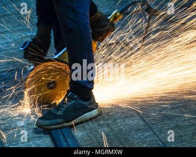 Mann schneidet Metall mit Winkelschleifer Stockfoto