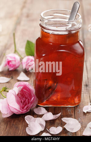 Glas rose Petal jam auf einem Holztisch Stockfoto