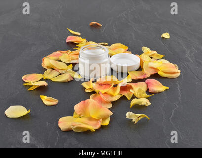 Naturkosmetik und Rosenblätter auf Schiefer Stockfoto