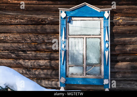 Gefrorenen Fenster in der Wand über alte, typisch russischen ländlichen Haus im Winter im kleinen Dorf in Smolensk Region Russlands Stockfoto