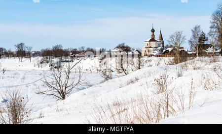 Stadtbild von Suzdal Stadt mit Heiligen Kreuzerhöhung und St. Cosmas und St. Damian Kirchen in Korovniki Bezirk am Ufer des zugefrorenen Fluss im Winter Stockfoto