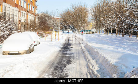 Schneebedeckte Autos entlang der Straße im Wohnviertel der Stadt Moskau im sonnigen Wintertag Stockfoto