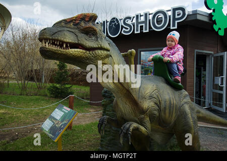 Moskau, Russland. 29. April 2018. Nicht identifizierte Mädchen sitzen auf Dilophosaurus in Dinosaur Park, Moskau, Russland Quelle: Alexander Mitrofanov/Alamy leben Nachrichten Stockfoto