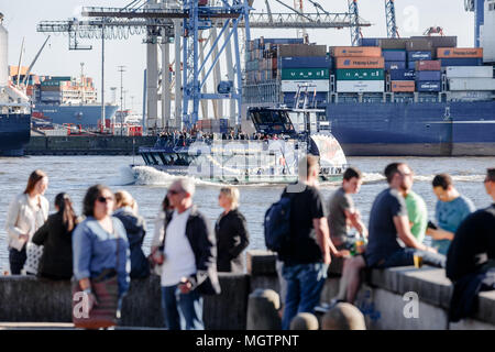 21 April 2018, Deutschland, Hamburg: Menschen genießen Sie die Nachmittagssonne auf einer Struktur für die Elbe an der Elbe Övelgönne Strand. Foto: Markus Scholz/dpa Stockfoto