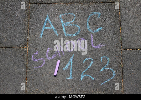 Schule, ABC Buchstaben und 123 Seufzer mit farbigen Kreiden auf einem Gehsteig geschrieben. Zeichnung wieder auf Asphalt in die Schule. Und Ferienhäuser Konzept. Bildung conc Stockfoto