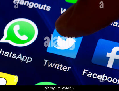 Finger, mit dem ein Symbol der Twitter App auf einem Tablet-PC oder Bildschirm des Smartphones zu laden. Twitter button. Stockfoto