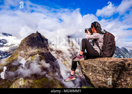 Natur-Fotograf-Tourist mit Kamera schießt beim stehen oben auf dem Berg. Wunderschöne Natur Norwegens. Stockfoto