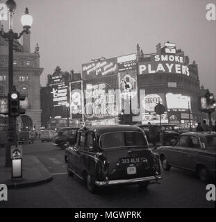 1960, historische Bild eines Londoner Taxi und ein Auto an der Ampel an der verkehrsreichen Kreisel warten, Piccadilly Circus, London, England, UK. Die berühmten Plakate mit Werbung für Marken wie "Zigaretten Spieler und Koks gesehen werden kann. Stockfoto