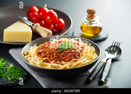 Köstliche Spaghetti mit Sauce Bolognese auf schwarzem Teller serviert Stockfoto
