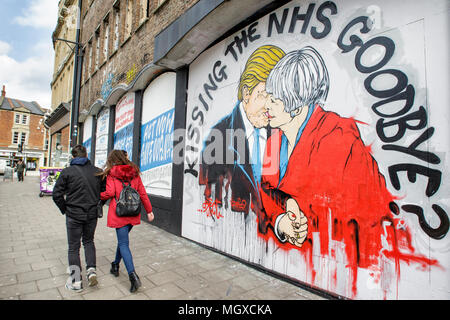 Bristol, UK. 24/02/17 Street Art Warnung über den Tod des NHS, Premierminister Mai + Präsident Trump küssen dargestellt in Stokes Croft ist Stockfoto