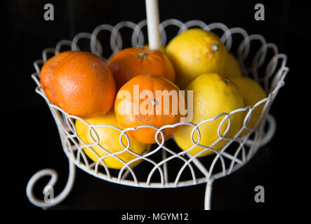 Frische Mandarinen und Zitronen in einem Drahtkorb Stockfoto