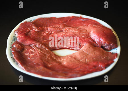 Weiße Platte mit zwei rohe Rindersteaks Stockfoto