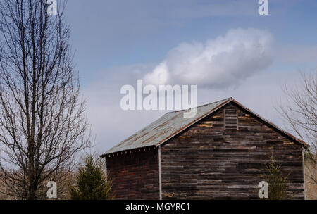 Puffy Cloud over an Old Barn Stockfoto