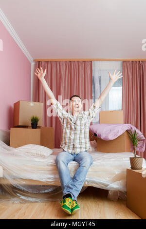 Fotos von glücklichen Mann sitzt auf einem Sofa unter Kartons Stockfoto