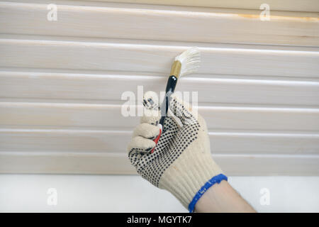 Auftragnehmer lackieren Holzpaneele an der Decke Stockfoto