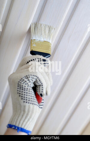 Auftragnehmer lackieren Holzpaneele an der Decke Stockfoto