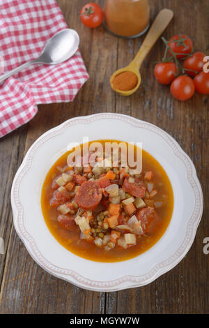 Linsensuppe mit Chorizo auf einem rustikalen Tisch Stockfoto