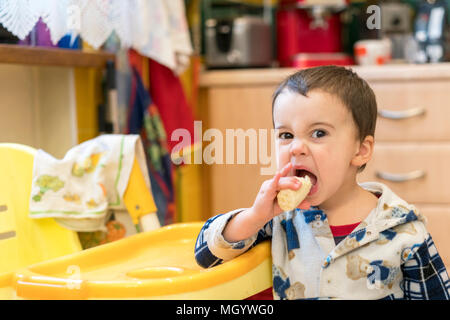Kind 2 Jahre alt, eine Banane essen in der Küche. Stockfoto