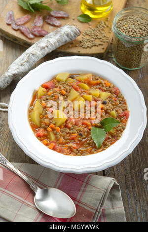 Linsensuppe mit Chorizo auf einem rustikalen Tisch Stockfoto