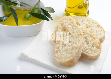 Ciabatta und grüne Oliven auf einem Zweig in Olivenöl Stockfoto