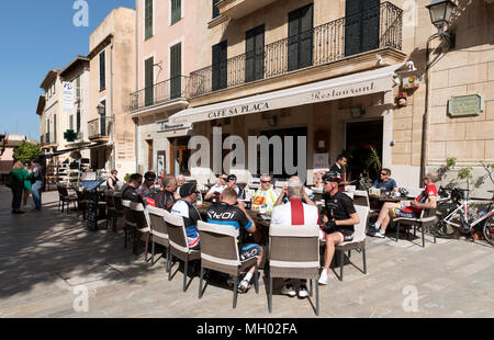 Alcudia, Mallorca, Balearen, Spanien. 2018. Restaurant und Radfahrer beim Mittagessen innerhalb der mittelalterlichen Mauer im Bereich der Alcudia Altstadt Stockfoto