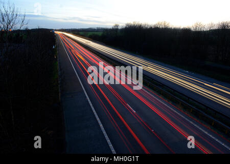 Weiß die Frontscheinwerfer sowie die roten Rückleuchten auf der Autobahn bei Nacht in Bewegung Stockfoto