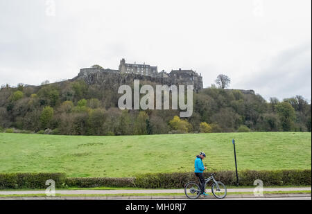 Stirling, Schottland, UK - April 29, 2018: Mann auf einem Fahrrad hält und nutzt Handy underneith Stirling Castle Schottland. Stockfoto