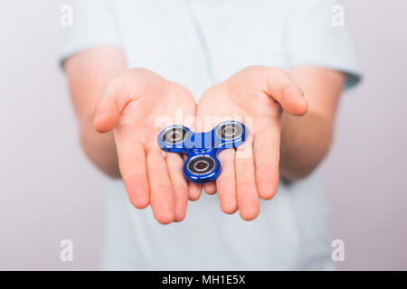 Männliche Hand beliebte zappeln Spinner toy auf weißem Hintergrund, Angst relief Spielzeug, Anti Stress und Entspannung fidgets Stockfoto