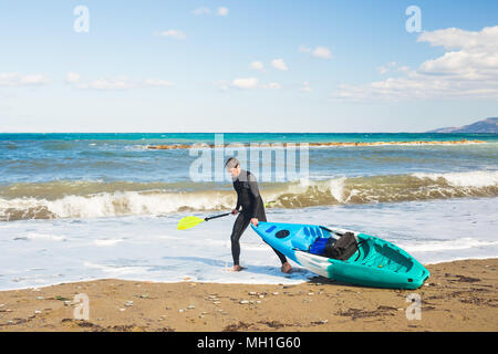 Mann, Kajak auf dem Meer Strand Stockfoto